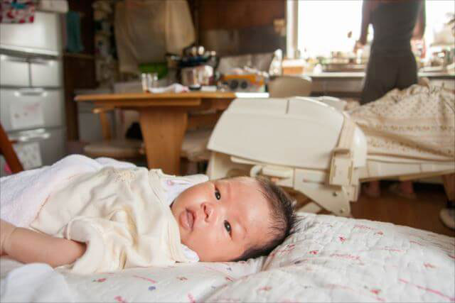 子供が寝ているところから離れて母親がいる