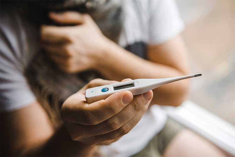 好転反応 発熱 体温計を見る女性