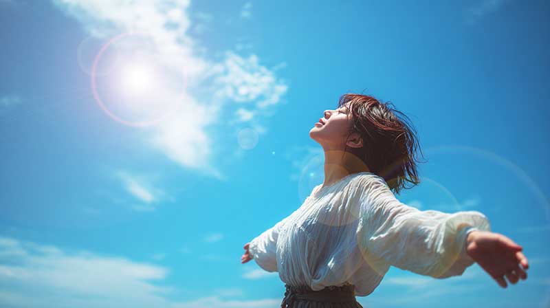 明るい空に向かって癒やされた女性