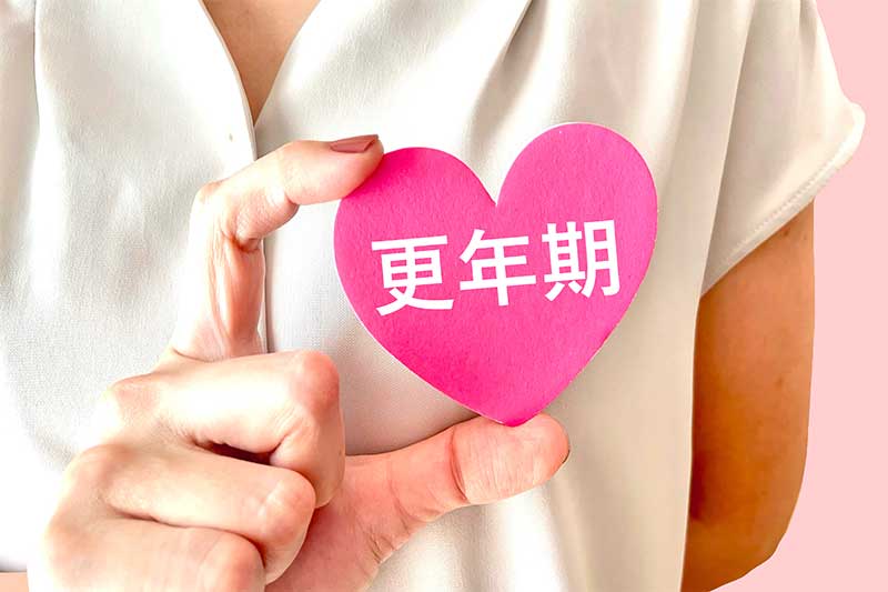 ホメオパシー 更年期 更年期と書いているハートを持っている女性の手