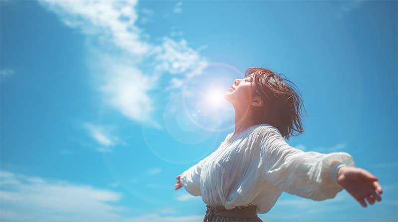 空にむかって手を広げている女性